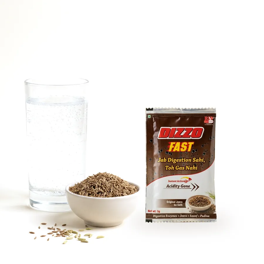 A Dizzo Fast sachet standing beside a glass of water and a bowl of cumin seeds