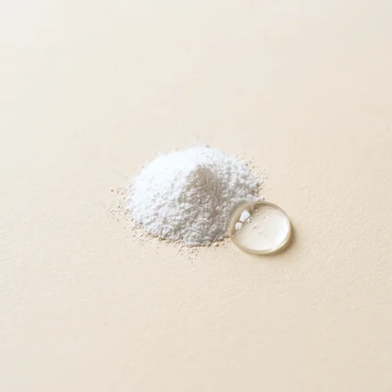 A small heap of fine white powder beside a clear bead of silicone fluid